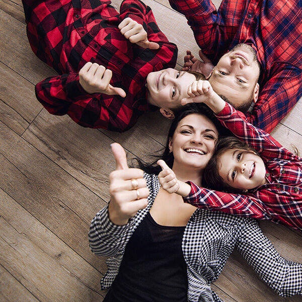 Happy family together at home lying on the wooden floor