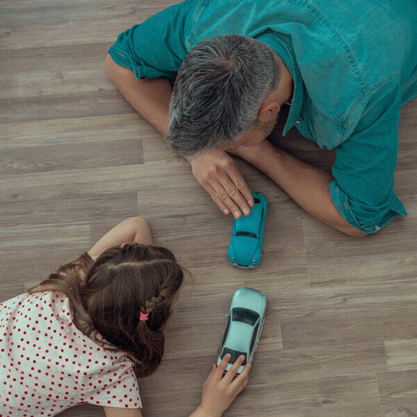 Father and daughter playing with toy car